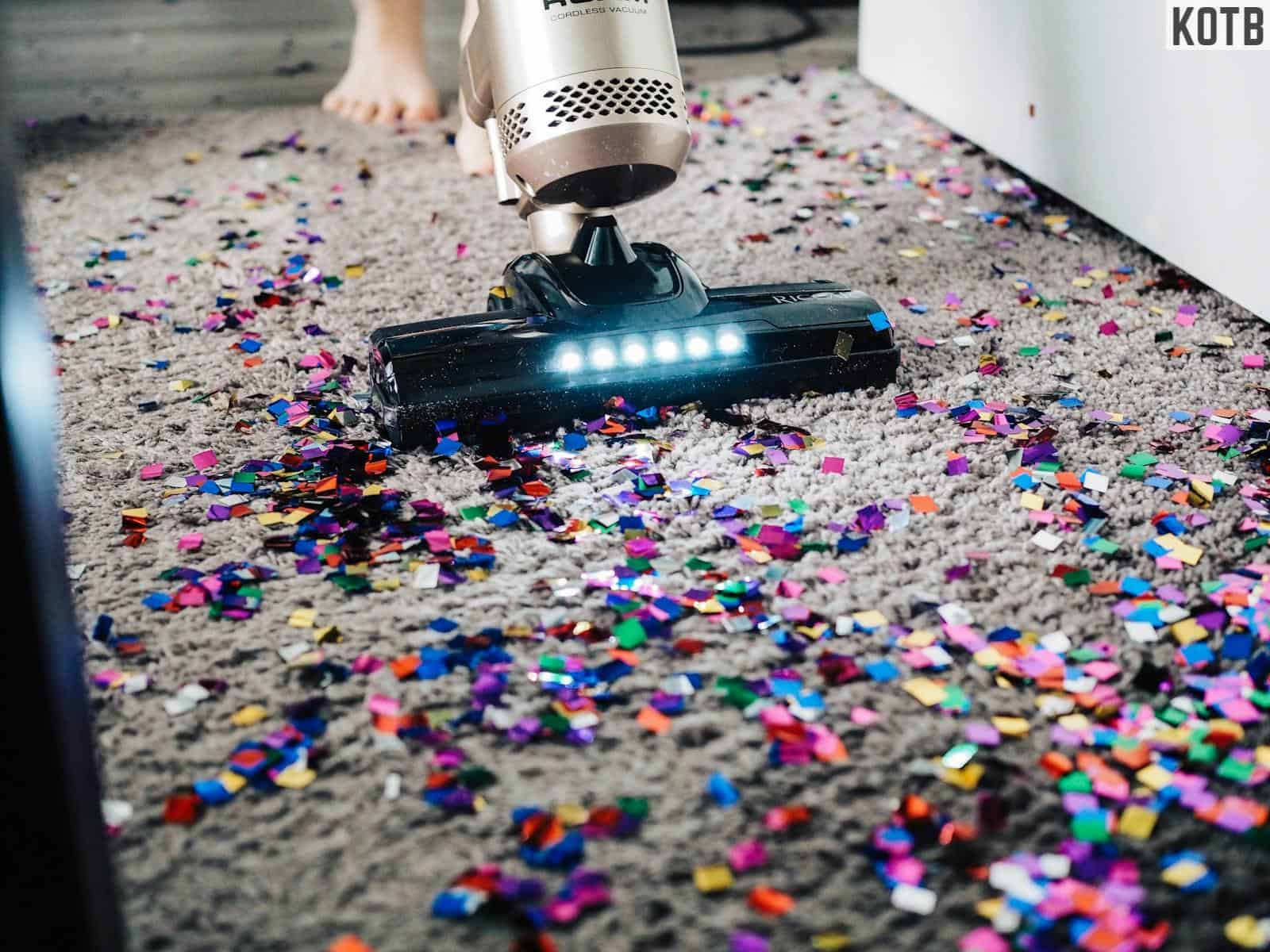 a person using a vacuum to clean a carpet