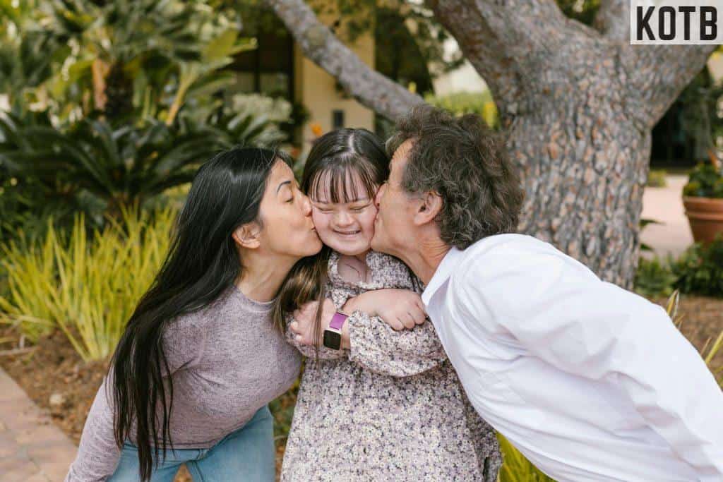 Parents Kissing Their Daughter's Cheeks