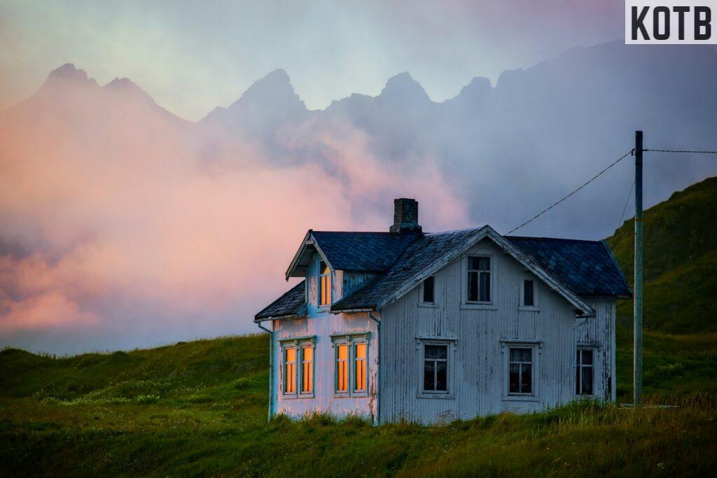 white and black house on green grass field under cloudy sky during daytime