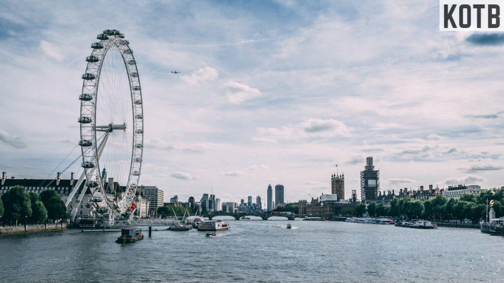 Scenic view of the London Eye on the River Thames with clear blue skies and city skyline.